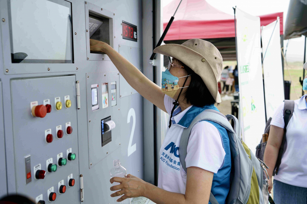 志工們將拾起的寶特瓶投入「好歸塑專車」，讓廢棄塑料空瓶可以直接粉碎、縮小體積，未來將可再製成購物袋、寶特衣、悠遊卡等生活用品